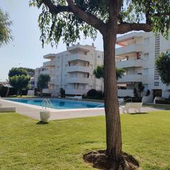 Pis a Calafell Residencial. Zona ajardinada con piscina y plaza de parking