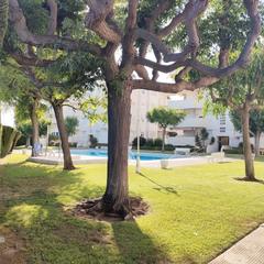 Pis a Calafell Residencial. Zona ajardinada con piscina y plaza de parking