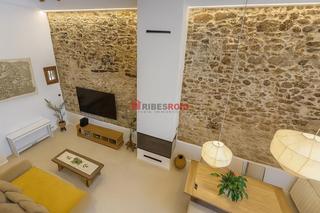 Casa a Centre. Casa de pueblo reformada con arco de piedra y vigas de madera en