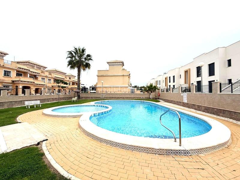 Foto 5001dac2-dbc7-4a6a-b13d-3b1e898f33e9. Casa pareada casa adosada esquinera de 3 dormitorios con su parking y piscina en villamartin en Orihuela